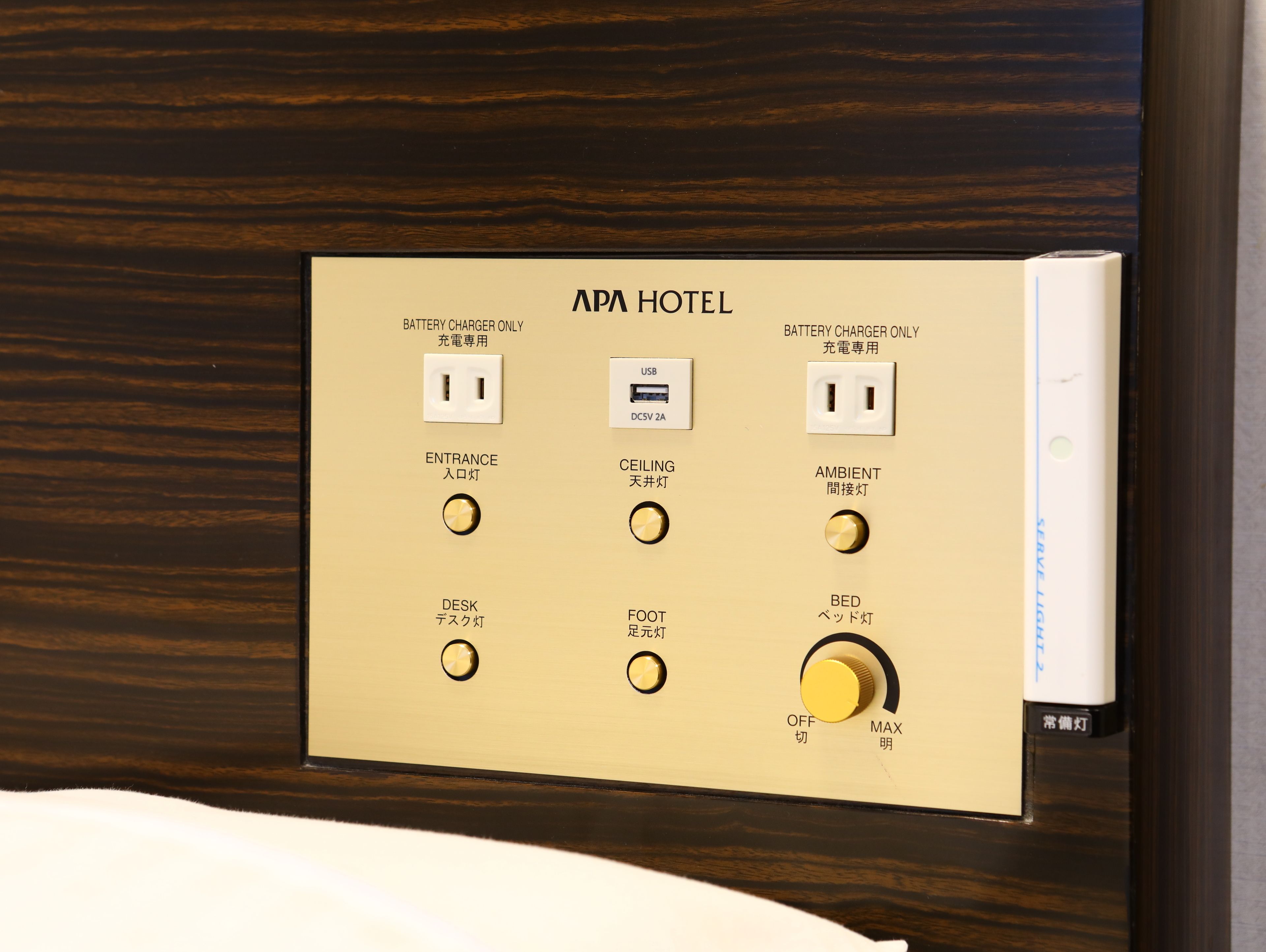 A control panel with labeled switches for battery charger, entrance, ceiling, ambient, desk, foot, and bed lighting.