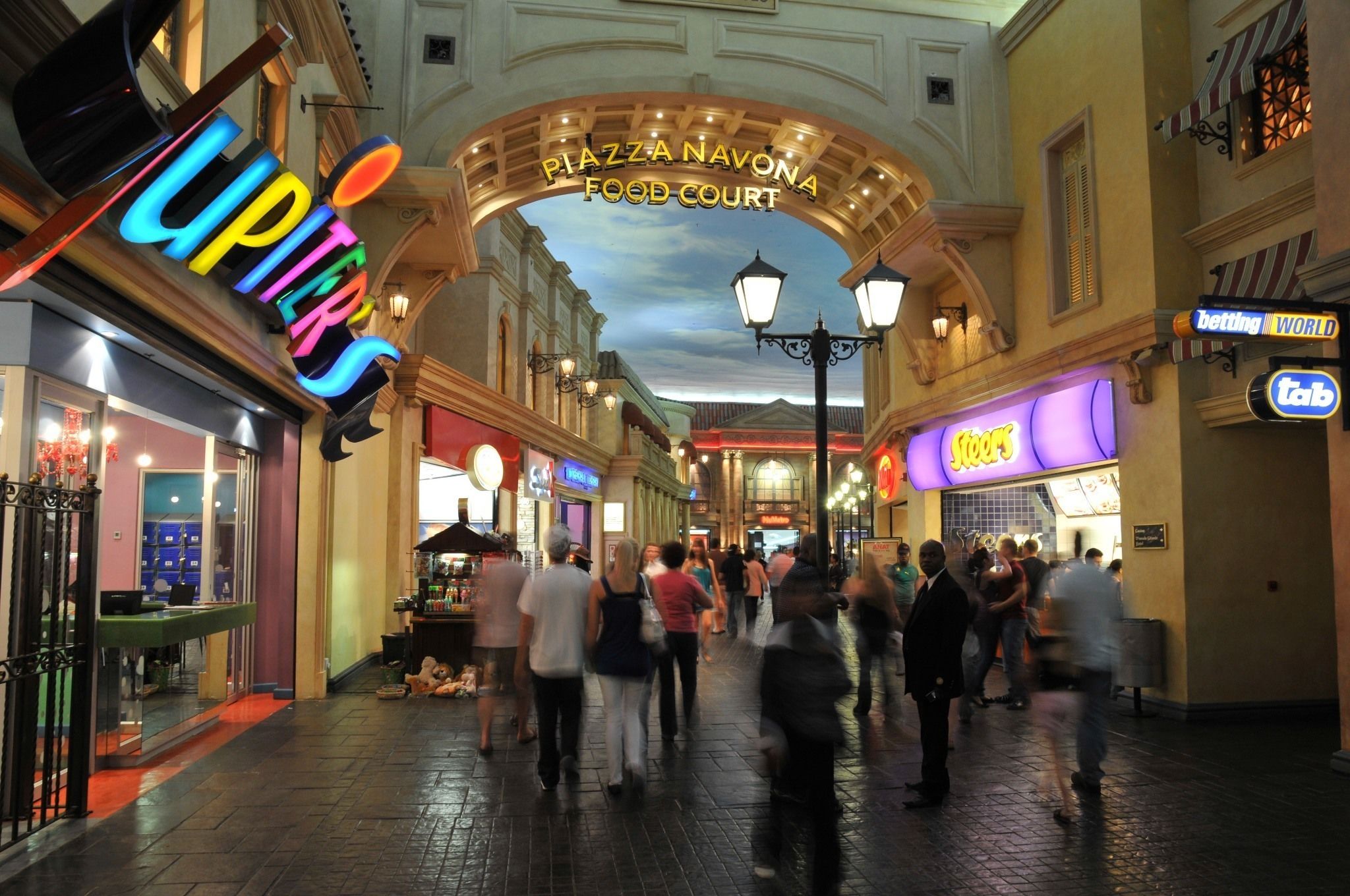 A bustling indoor pedestrian area with a prominent archway labeled "PIAZZA NAVONA FOOD COURT".