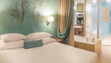 Quarto de hotel com cama, parede com mural, banheiro com banheira e chuveiro.