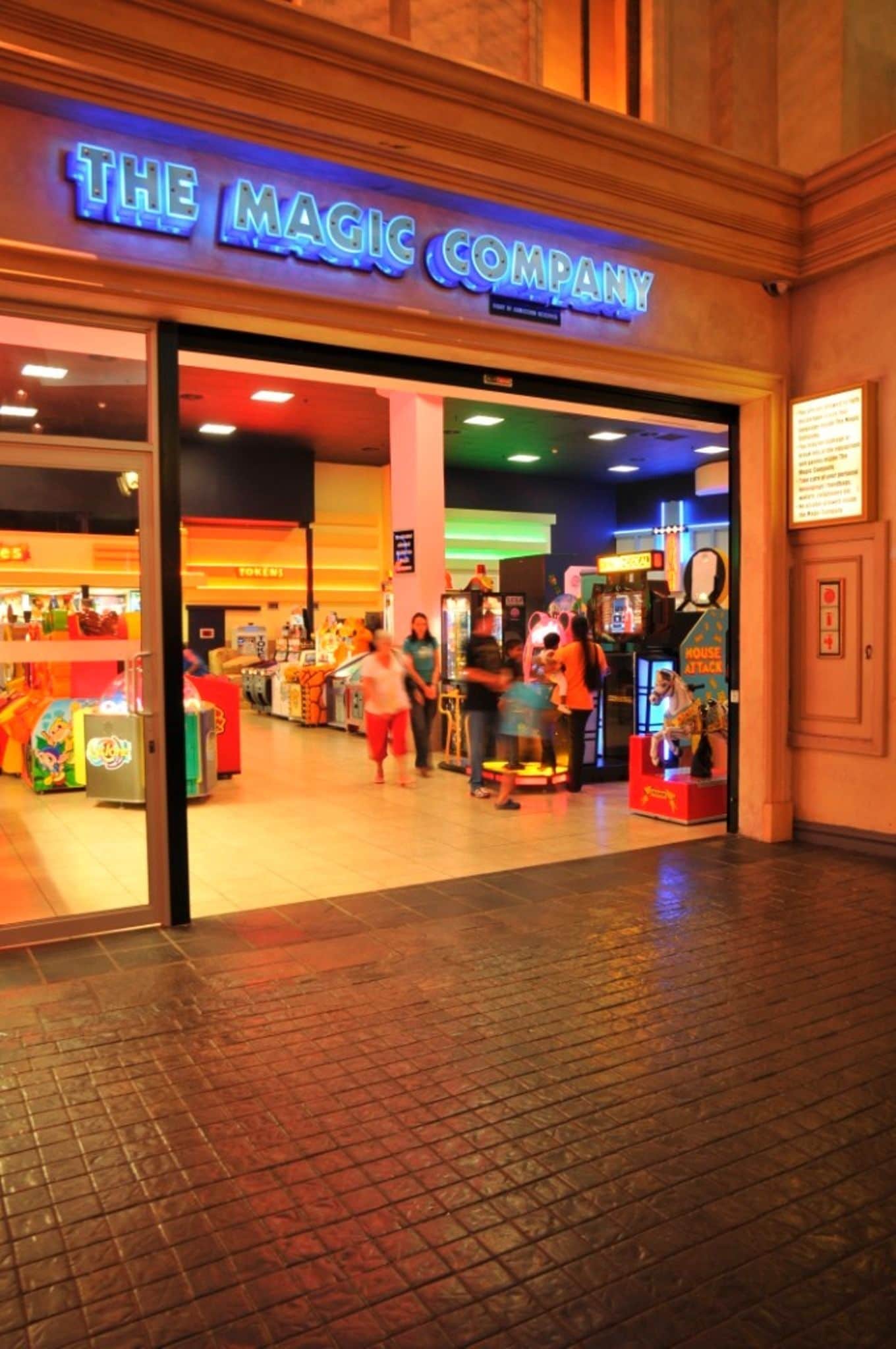 La entrada a The Magic Company, con juegos de arcade y un letrero muy iluminado.