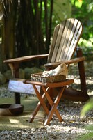 Una silla de madera con una cesta trenzada y un paño en el asiento, sobre un tapete tejido.