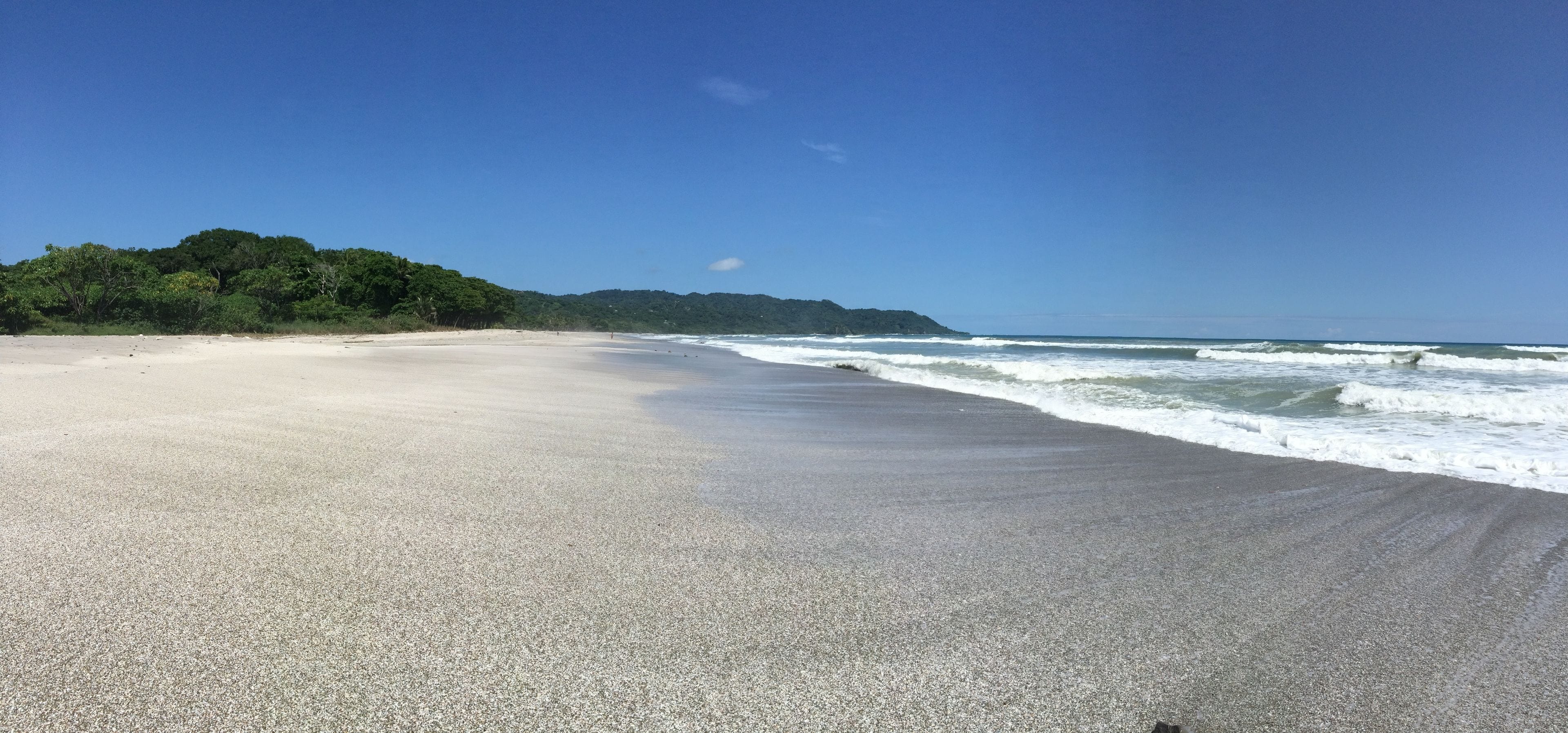 A beach with a sandy shore and waves.