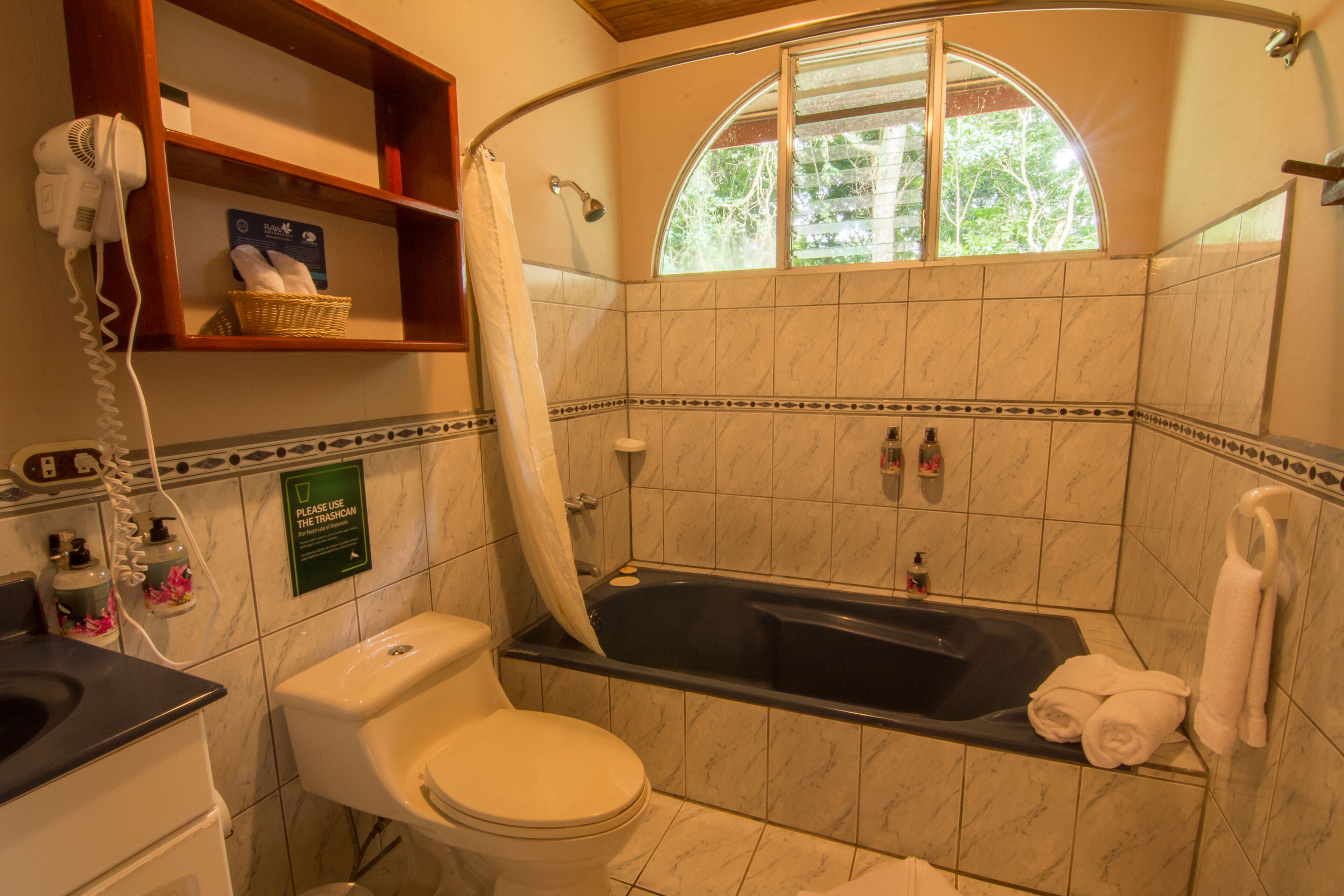 A bathroom with a bathtub, toilet, and a shower curtain.