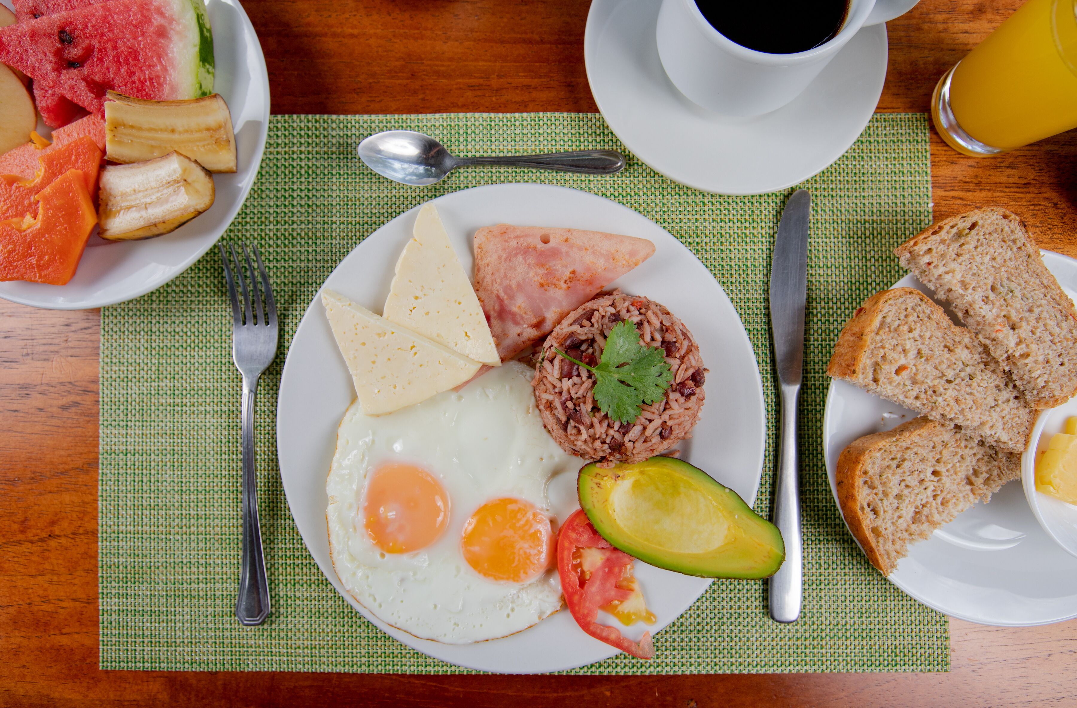 Une assiette de petit-déjeuner composée d’œufs, d’avocat, de tomates et de riz.