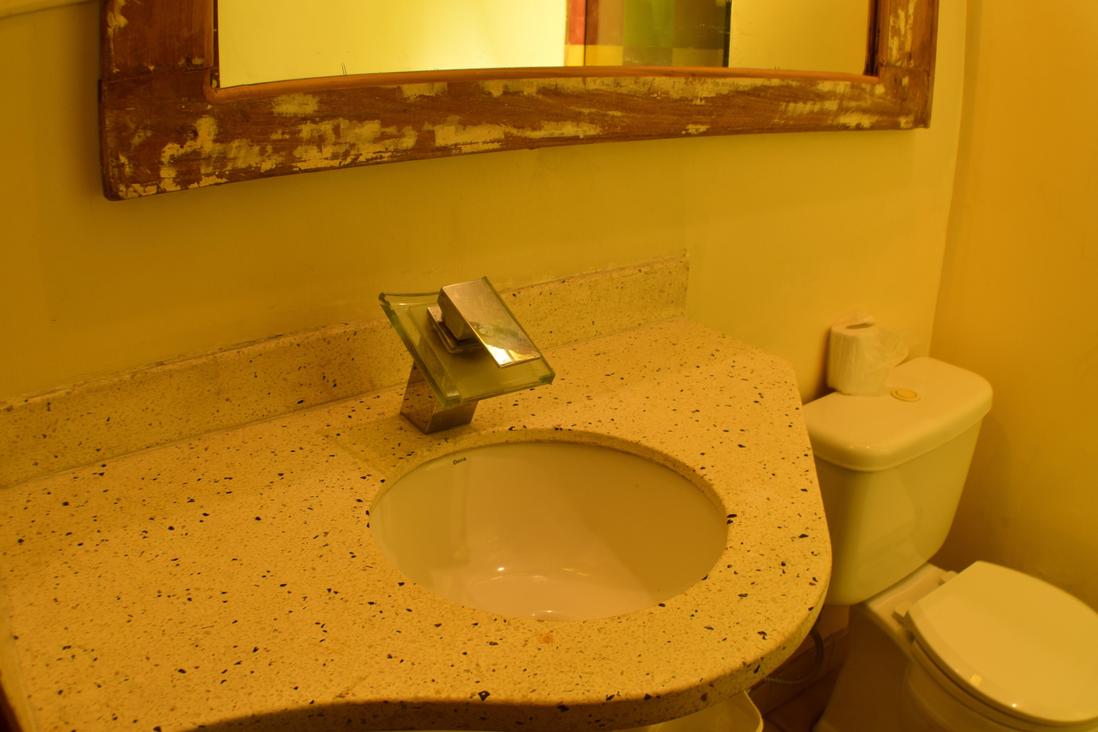 A bathroom with a sink, mirror, and toilet.