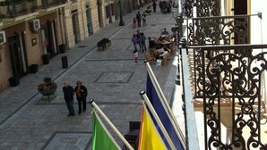 A hotel courtyard with a central open space, flagpoles, and a balcony with wrought iron railings. - Hotel Medici (Milazzo)