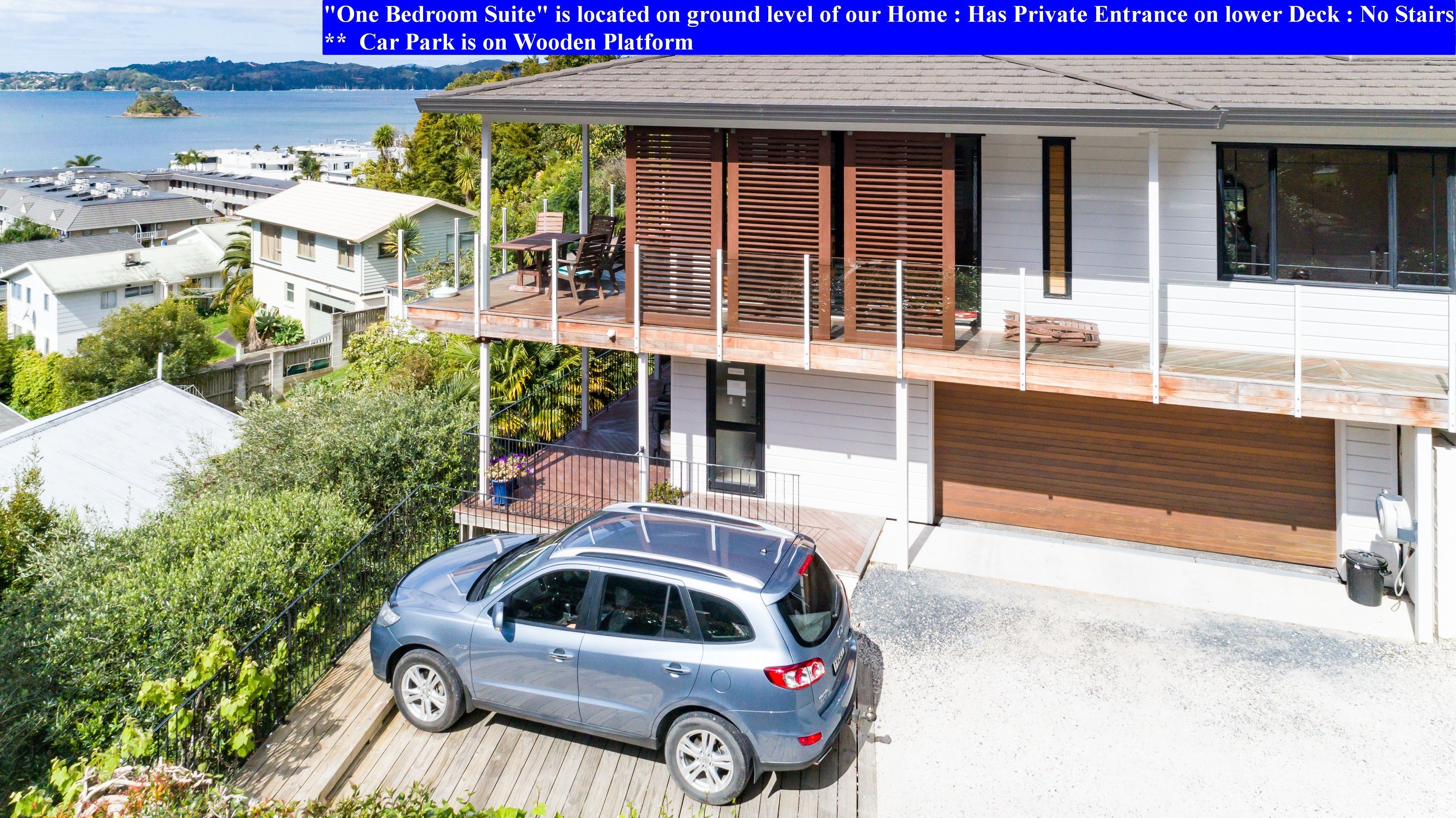 A modern two-story house with a private entrance on the lower deck, no stairs, and a car park on a wooden platform.