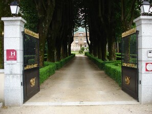 Una entrada protegida por una reja, con un sendero que lleva a un edificio.