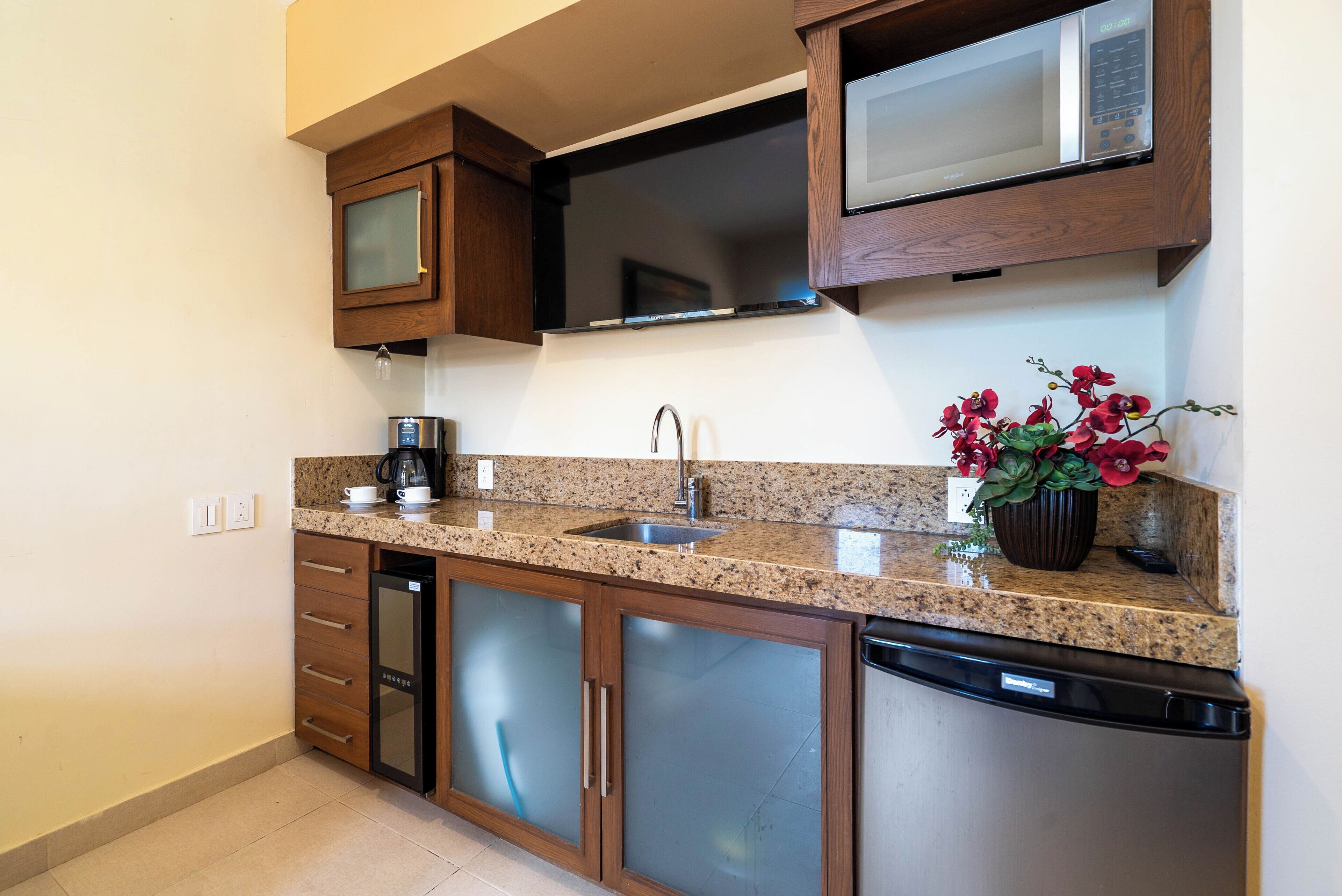 Eine moderne Küche mit Granit Arbeitsplatten, Edelstahlgeräten und Holzschränken.