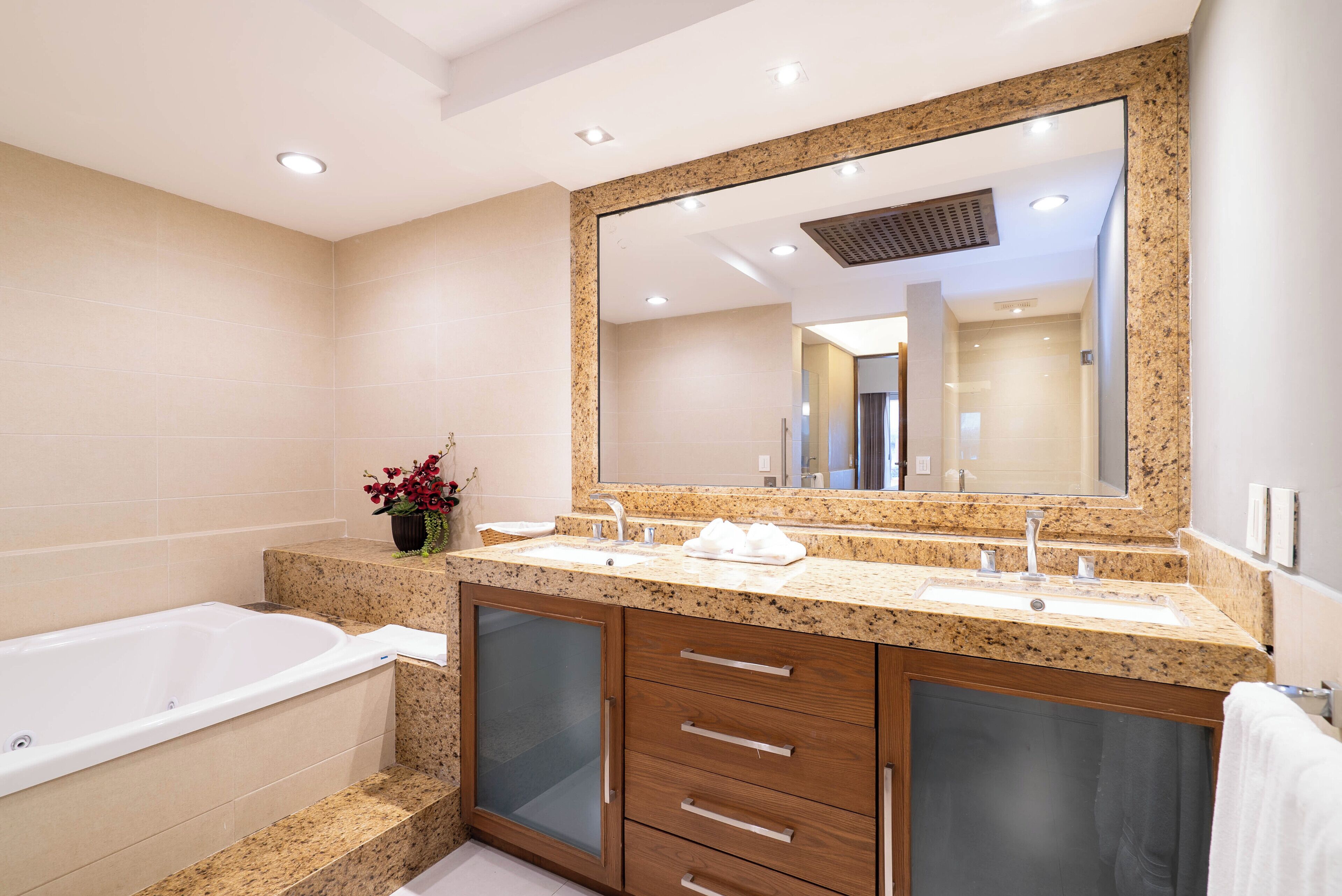 A modern bathroom with a freestanding bathtub, a double sink vanity, and a large mirror.
