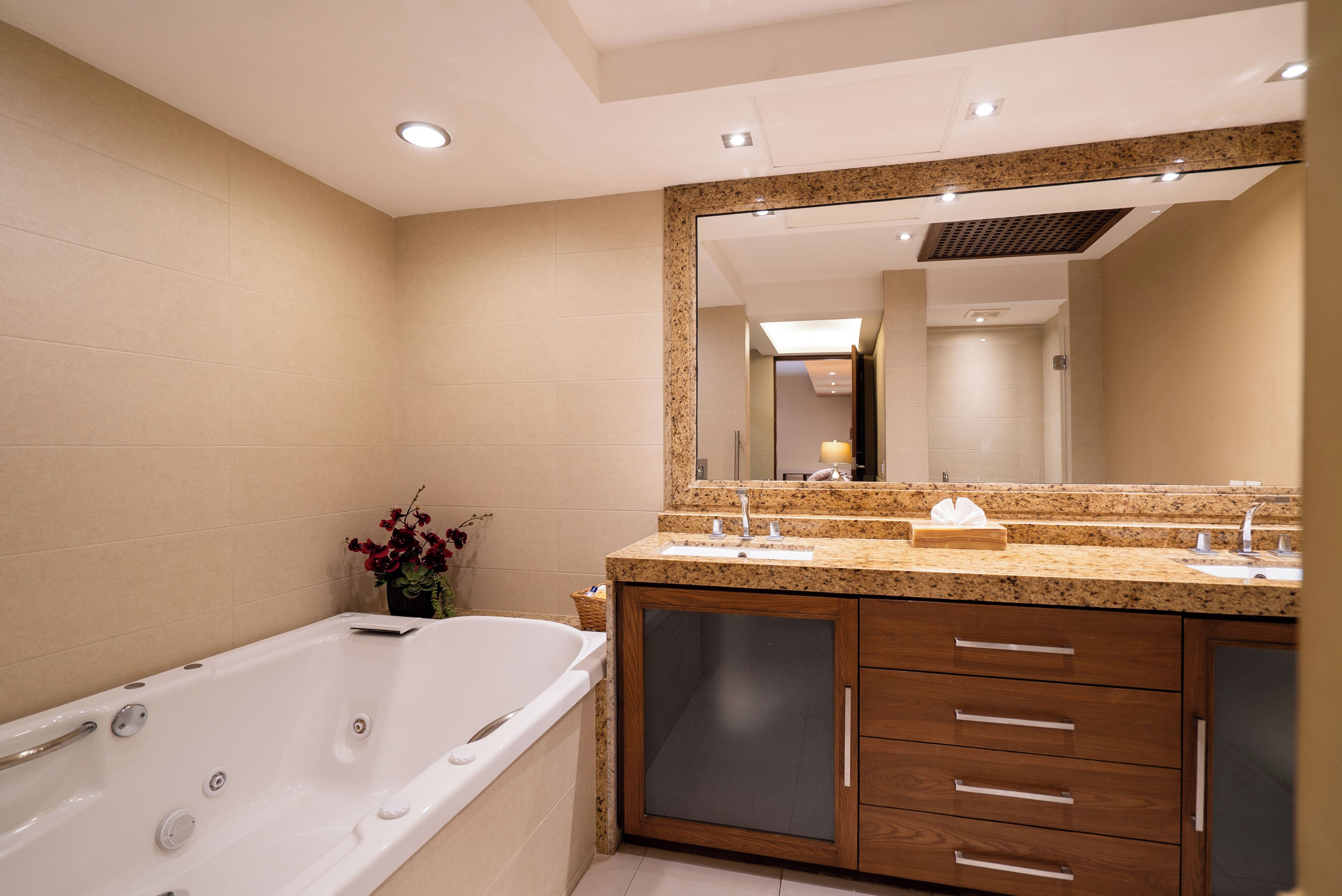 A modern bathroom with a freestanding bathtub, a large mirror, and wooden cabinetry.