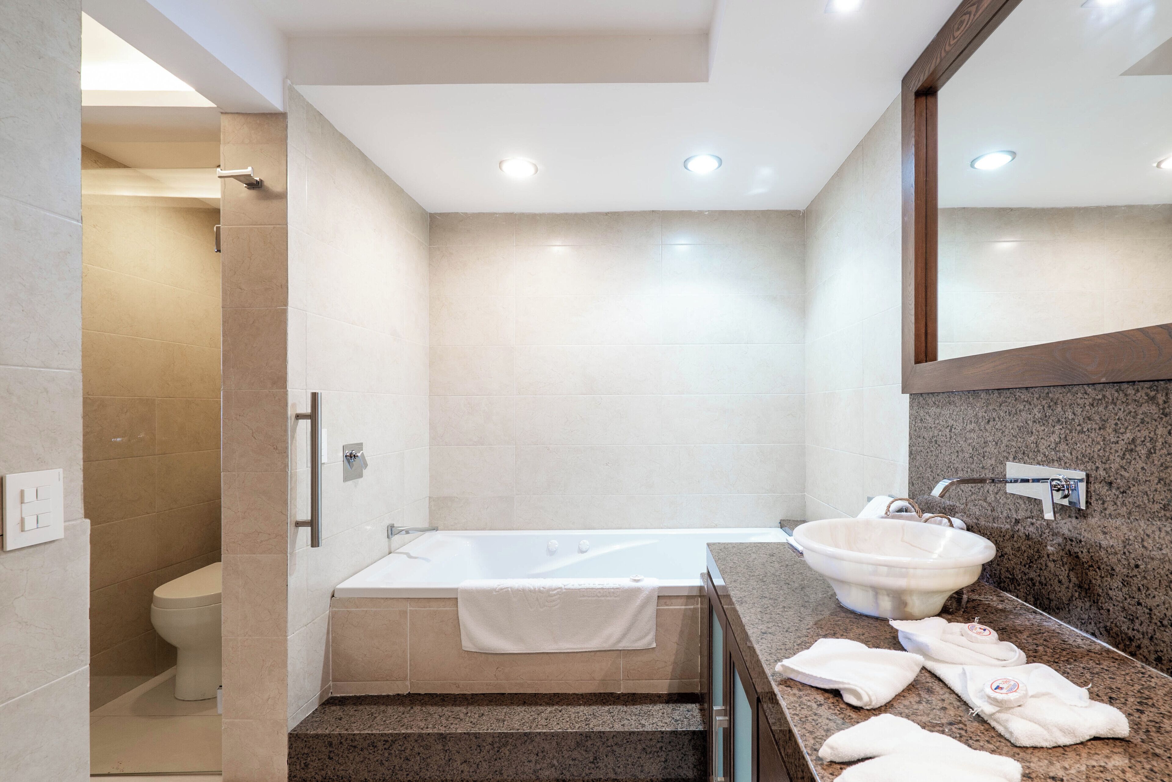 Een moderne badkamer met een bad, een wastafel en een toilet.