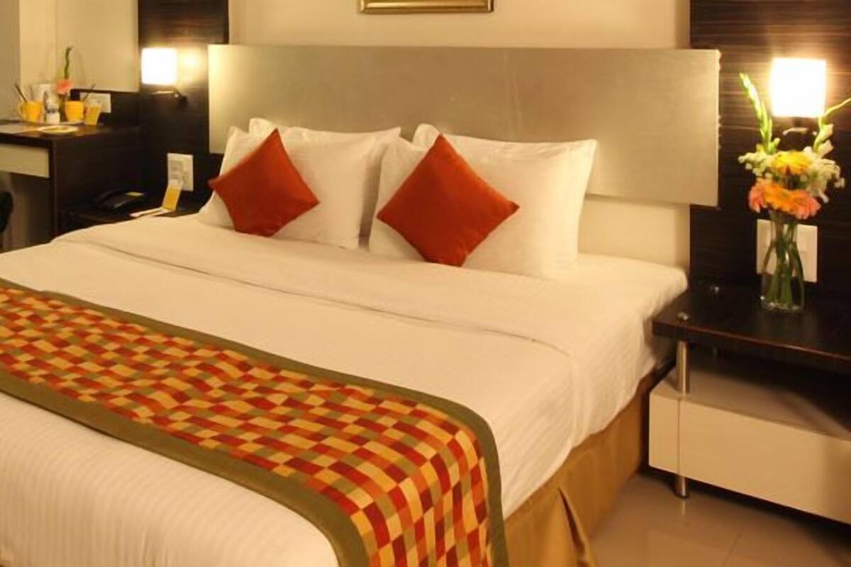 Una habitación de hotel con cama, escritorio y silla.