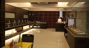 A modern restaurant with a central counter, seating area, and a chef at the counter. - Keys Select by Lemon Tree Hotels, Nestor, Mumbai (Mumbai)