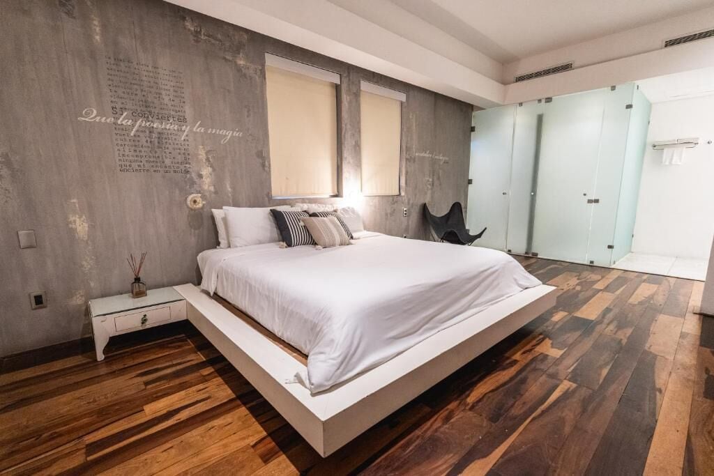 Un dormitorio moderno con una cama grande, suelo de madera y un armario con puertas correderas.