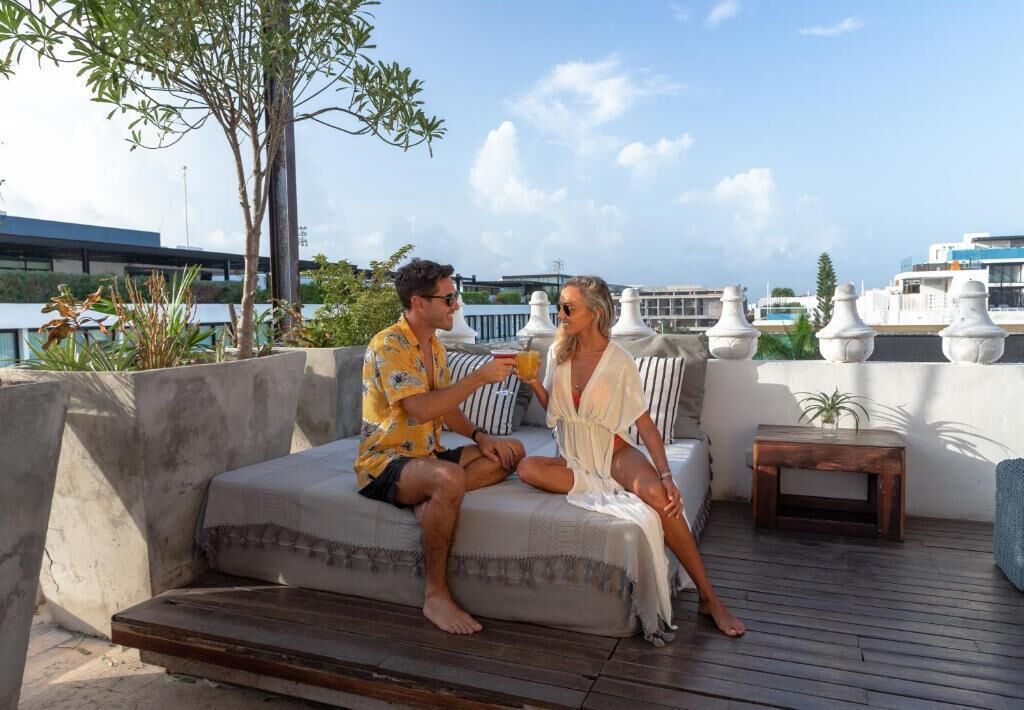 A couple sitting on a sofa with a view of boats and buildings in the background.