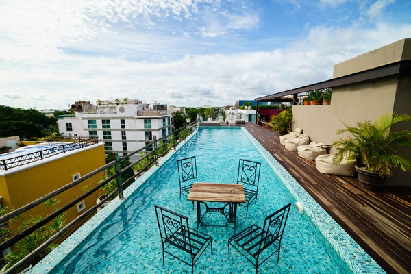 Una piscina al aire libre, sombrillas, sillones reclinables de piscina