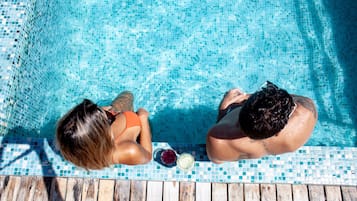 Een buitenzwembad, parasols voor strand/zwembad