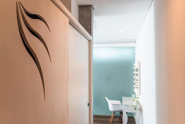 Un pasillo de diseño moderno, una silla blanca y una mesa con iluminación.