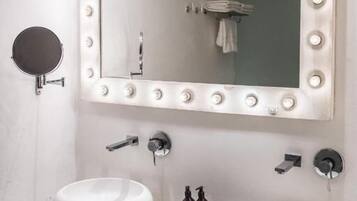 Une salle de bain avec deux lavabos, un grand miroir avec éclairage intégré et un porte-serviettes.