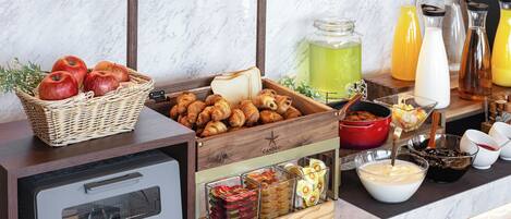 A breakfast buffet with various food items, a toaster, and beverage dispensers.