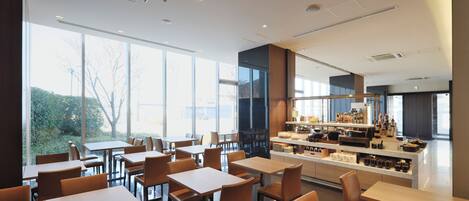 A modern restaurant with a bar area, large windows, and a clean, contemporary interior.