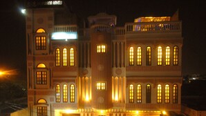A multi-story building with illuminated windows and a sign that reads "Hotel." - Rajputana Haveli (Jaipur)