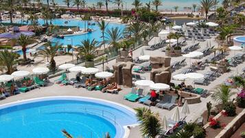 Een binnenzwembad, een buitenzwembad, parasols voor strand/zwembad