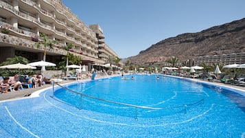 Een binnenzwembad, een buitenzwembad, parasols voor strand/zwembad