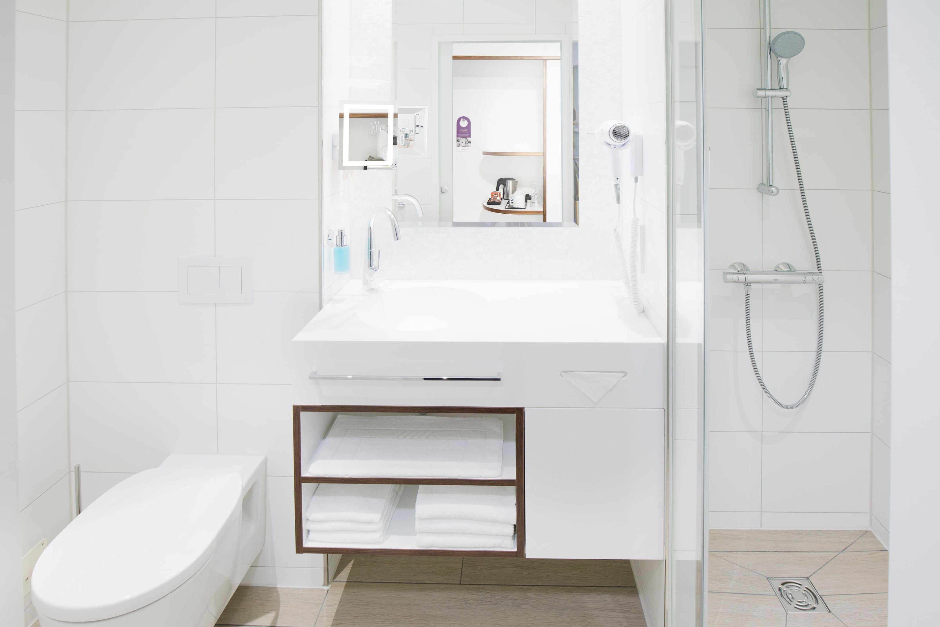 Un bagno moderno con toilette, lavandino e doccia.
