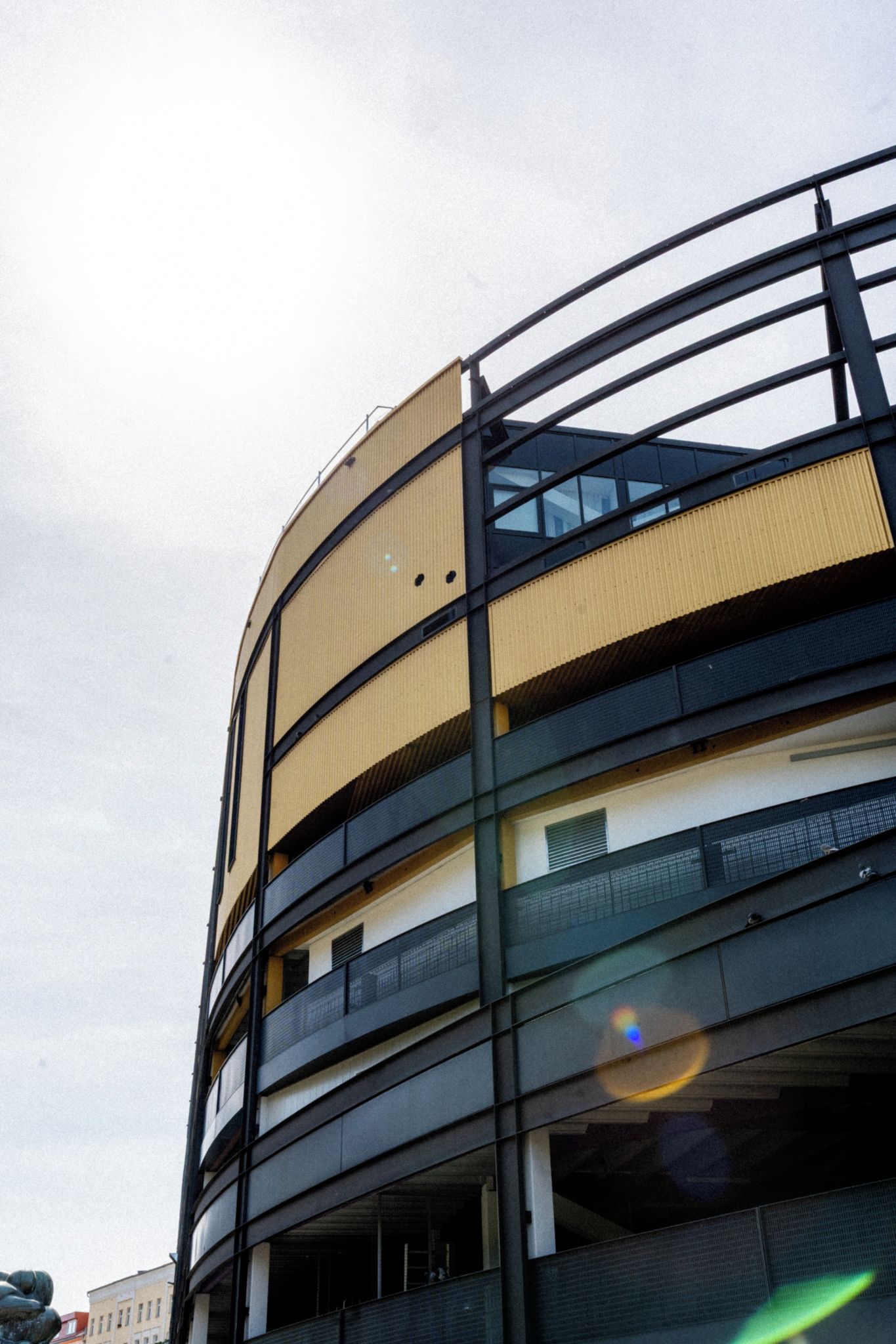 A multi-story building with a curved facade, balconies, and a series of windows.