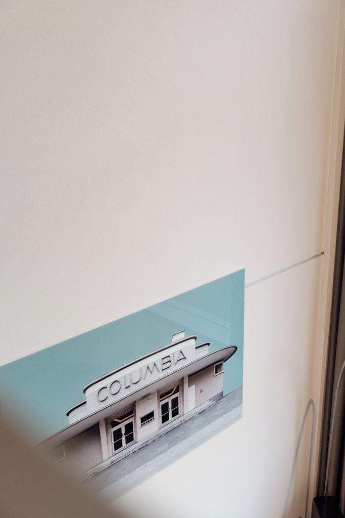 Una pared con un gráfico de un edificio que dice 'COLUMBIA' y una vista parcial de un marco de puerta.