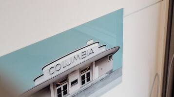Una pared con un gráfico de un edificio que dice 'COLUMBIA' y una vista parcial de un marco de puerta.