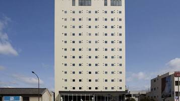 A tall, modern hotel building with a flat facade and numerous windows.