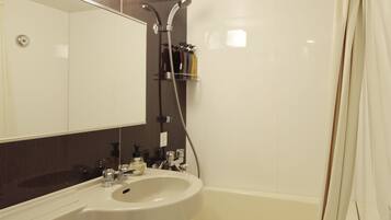 Uma casa de banho moderna com sanita, lavatório e chuveiro.
