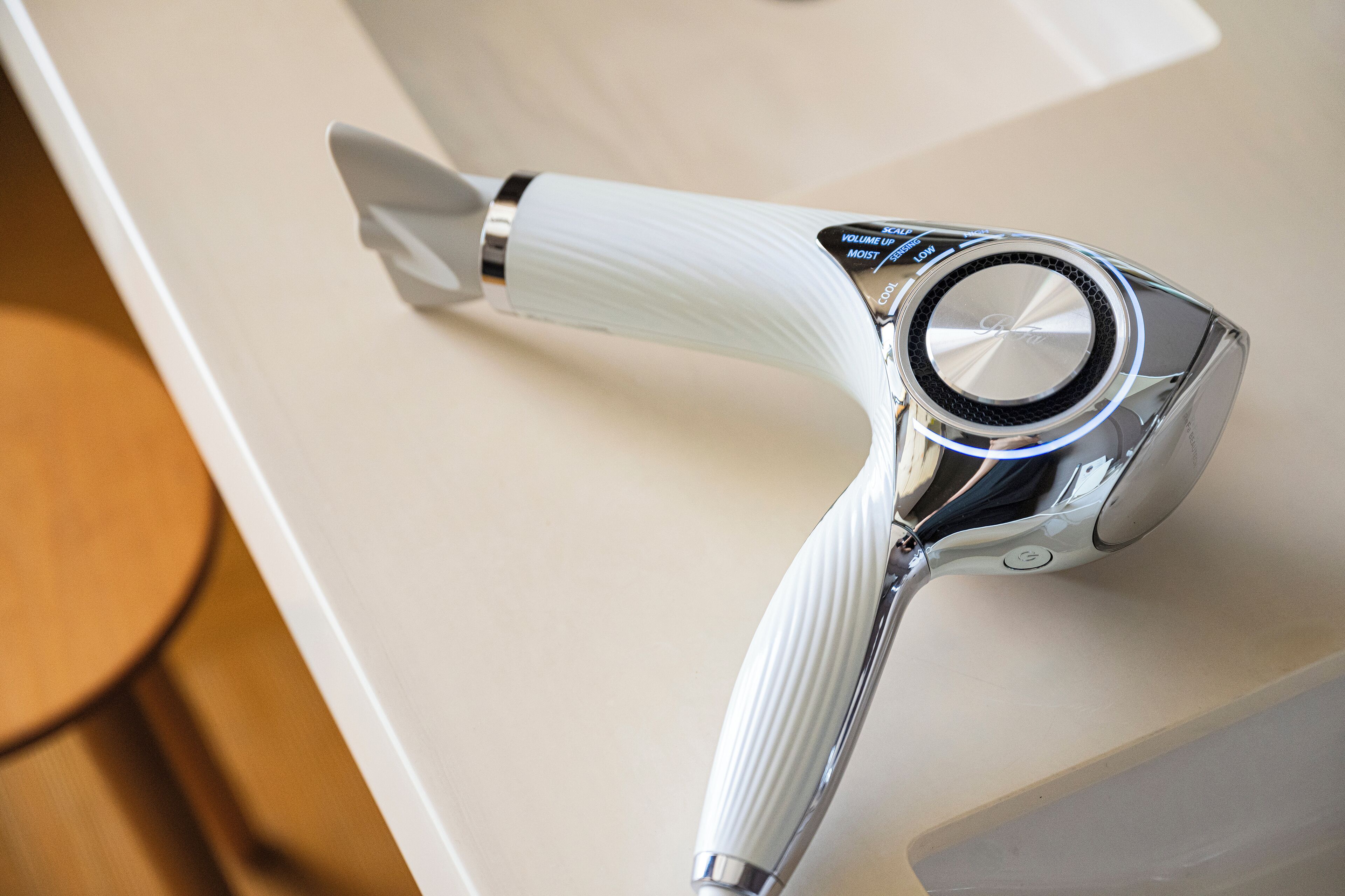 A hair dryer with a ribbed handle and a control panel with volume and heat settings.