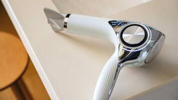 A hair dryer with a ribbed handle and a control panel with volume and heat settings.