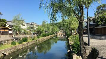 Une ville japonaise traditionnelle, avec une rivière paisible, des bâtiments historiques et un pont piétonnier.