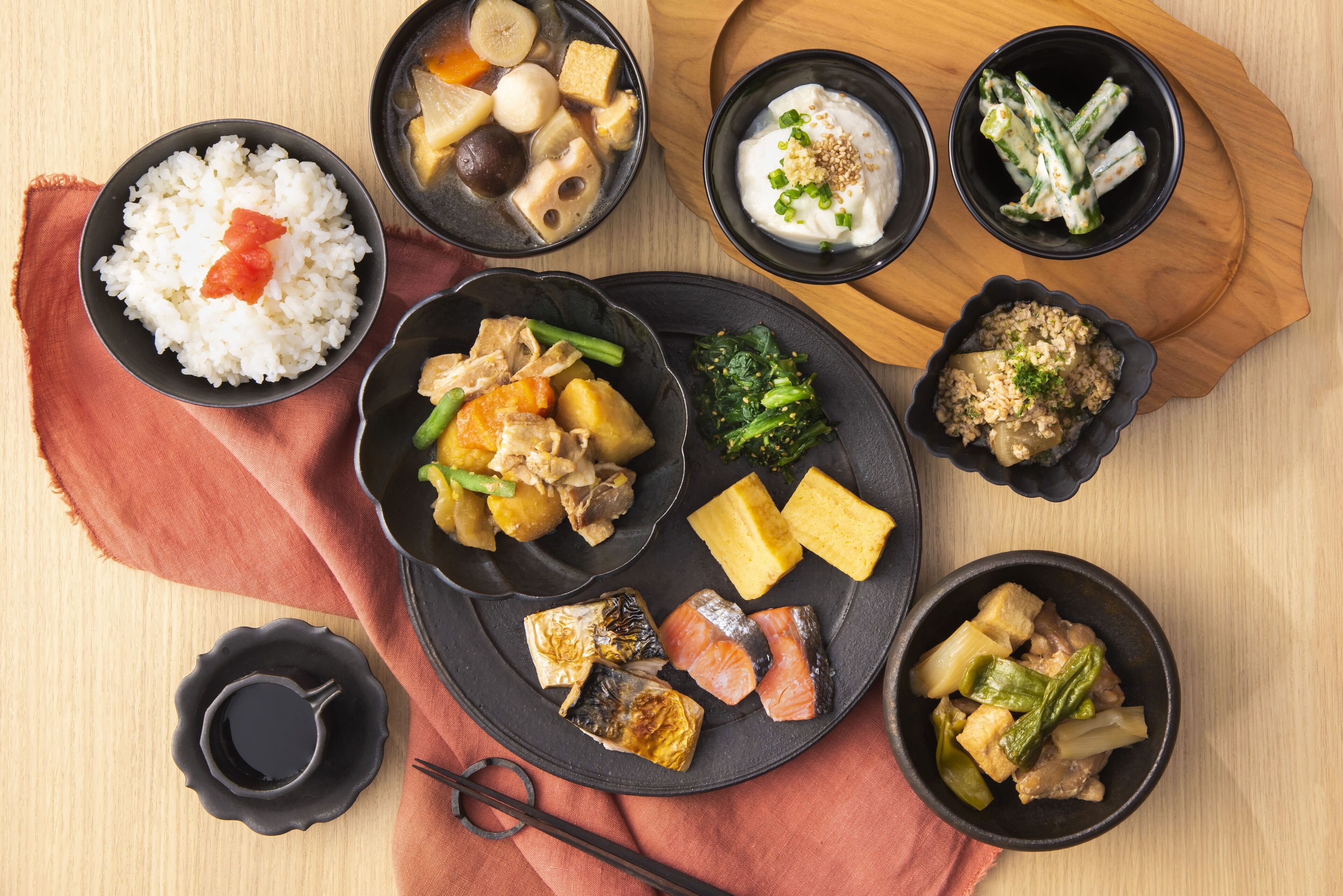 Variedad de platos que incluyen arroz, tofu y verduras sobre una mesa de madera.