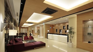 A modern hotel lobby with a reception desk, seating area, and a large plant. - Candeo Hotels Kumamoto Airport Kikuyo (Kikuyo)