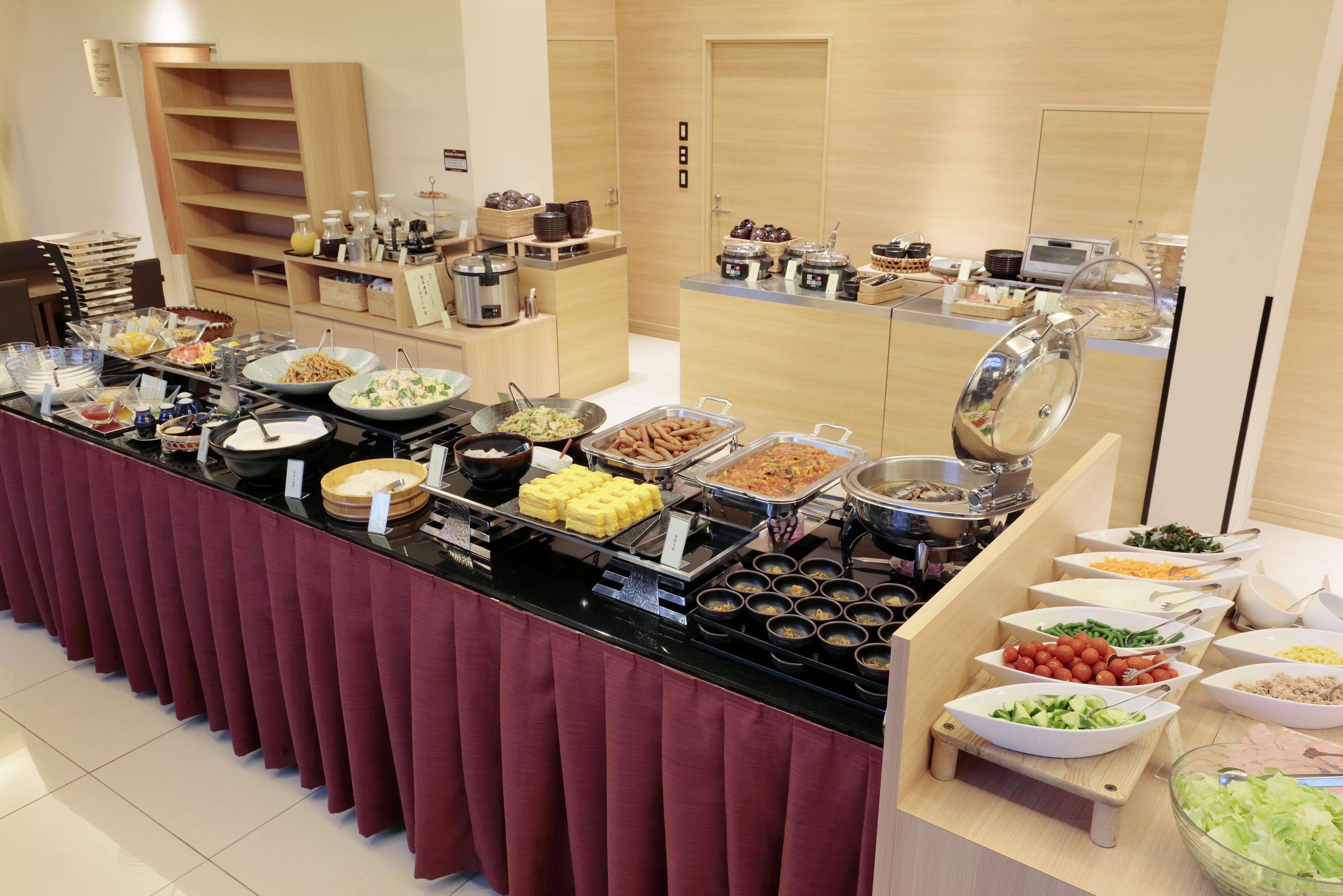 A buffet with various food items and a coffee station.