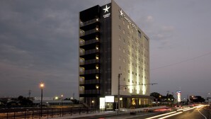 A tall hotel with multiple floors and balconies, featuring a prominent star logo on the facade.
