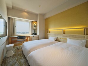 A hotel room with a large bed, a desk, a chair, a toilet, and a window with a view. - Candeo Hotels Sano (Sano)