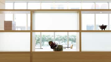 A room with a large window, a wooden bench, and a small table with a decorative item.