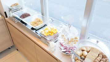 A buffet with various food items including fruits, nuts, and pastries.