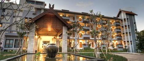 Un hotel moderno con un cortile centrale, una grande fontana e numerosi balconi.