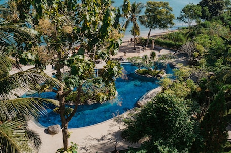 Una piscina al aire libre, sombrillas, sillones reclinables de piscina