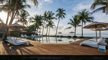 Una piscina al aire libre, sillones reclinables de piscina