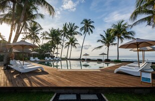 Una piscina al aire libre, sillones reclinables de piscina