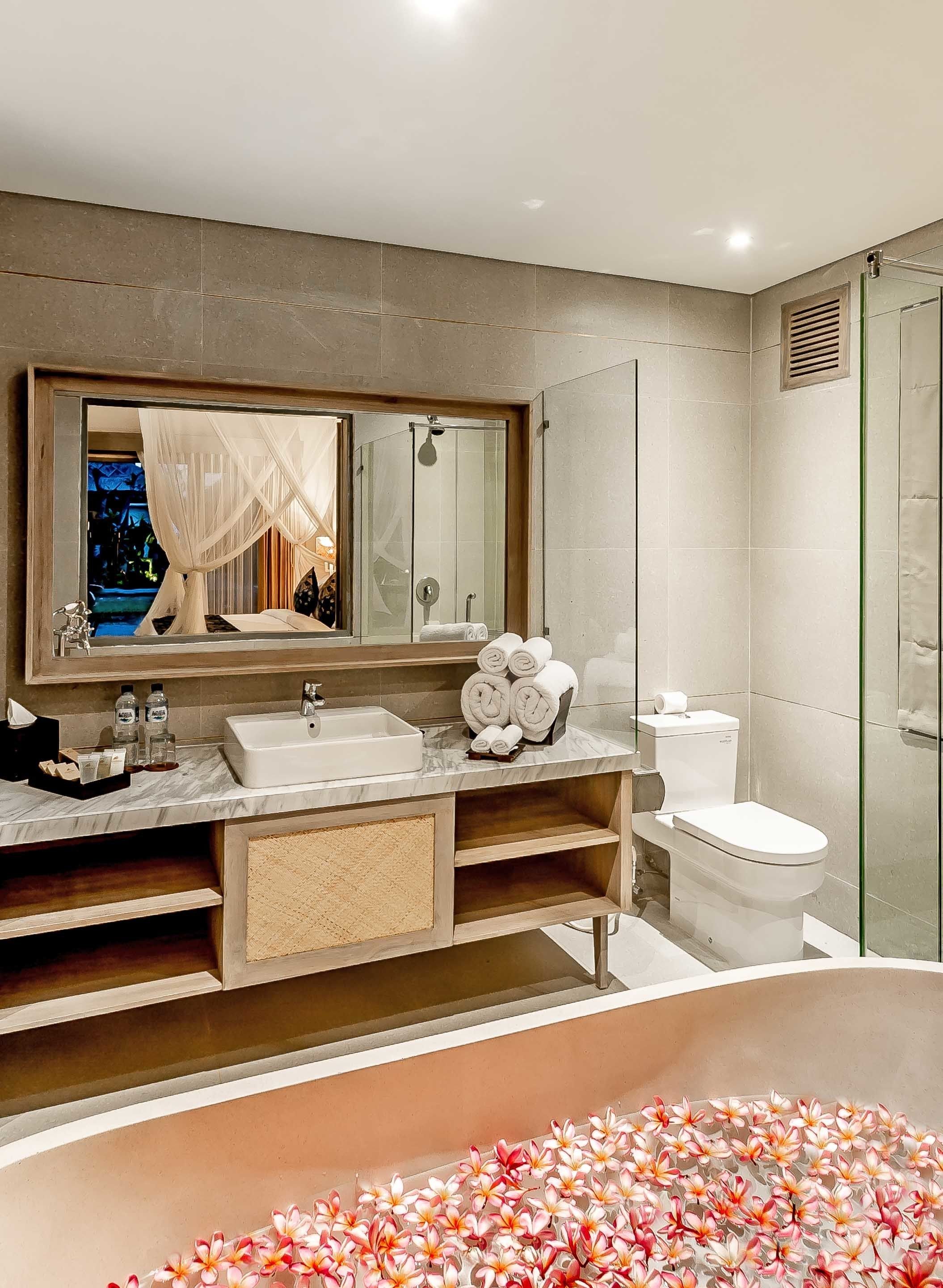 A modern bathroom with a large bathtub, a sink, and a toilet.